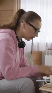 Kapüşonlu kadın Coronavirus sırasında dizüstü bilgisayar kullanarak evden iş yapıyor.