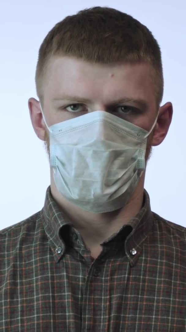 Tir vertical L'homme déchire le masque médical contre le covide 19. Arrêter la pandémie de coronavirus en quarantaine — Video