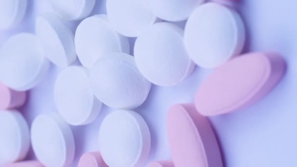 Vertical video Pink oval tablets are neatly arranged in small white pills. Closeup rotation — Stock Video