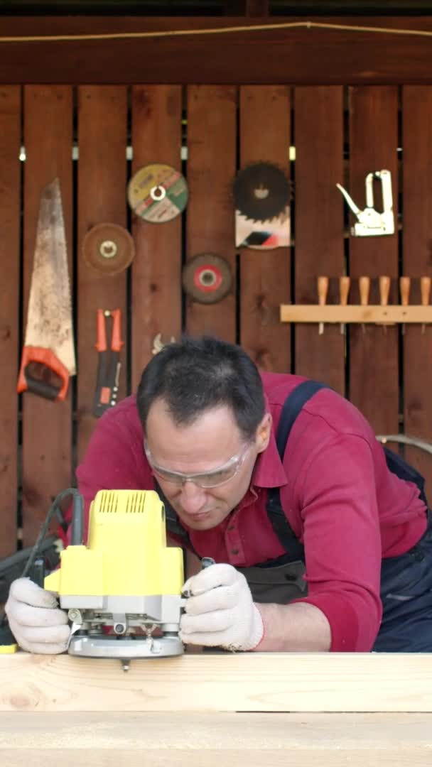 Tiro vertical Woodworker procesa madera con una fresadora en su taller de carpintería — Vídeos de Stock