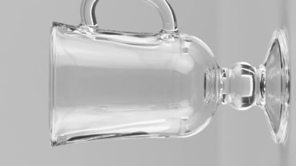 Вертикальне відео Молоко вливається в скляний кухоль для латте крупним планом ізольовано на світло-сірому фоні — стокове відео
