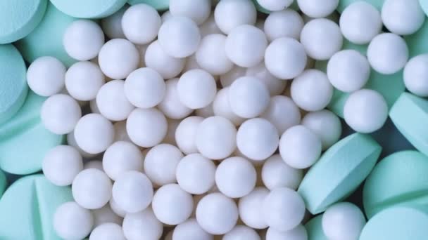 Κάθετη βίντεο Οι λευκοί κόκκοι είναι διάσπαρτοι σε στρογγυλά φωτεινά πράσινα αντιβιοτικά. Περιστροφή — Αρχείο Βίντεο