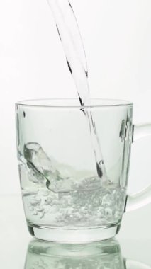 Dikey video kristal berrak su cam bardağa dökülüyor