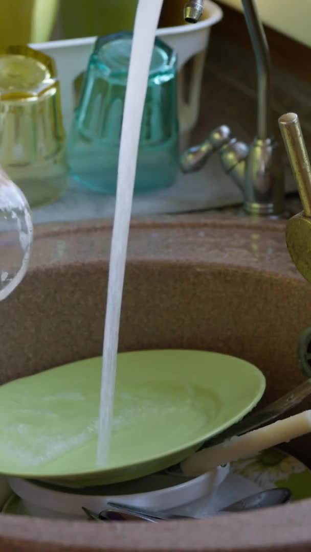 Vertikální záběr Žena v domácnosti myje špinavý skleněný kelímek ve dřezu houbou s čisticím prostředkem. — Stock video