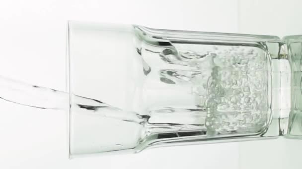 Vídeo vertical Agua cristalina vertiendo en vidrio facetado — Vídeo de stock