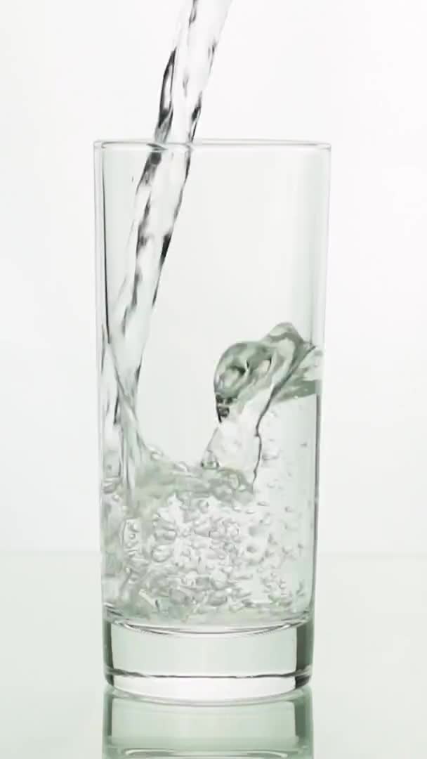 Verticale video Kristalhelder water gieten in glas — Stockvideo