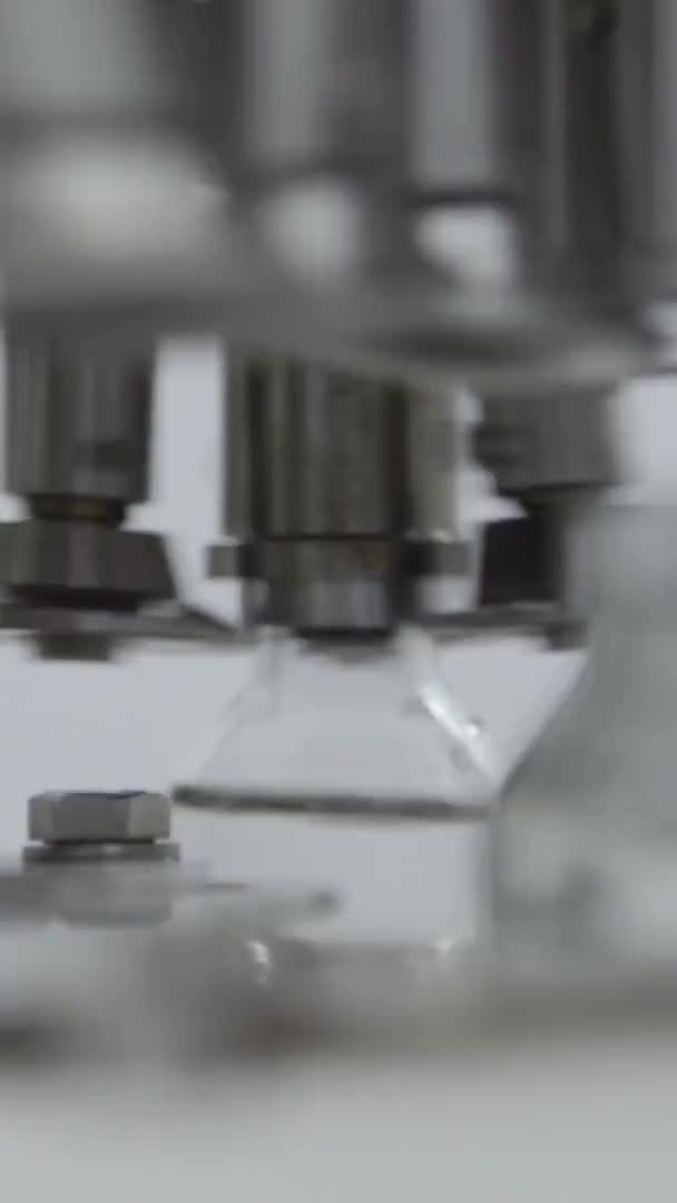 Bottiglie di vetro video verticali riempite e sigillate con tappi in gomma su una linea di trasportatori per soluzioni mediche sezione di confezionamento tappi in alluminio — Video Stock