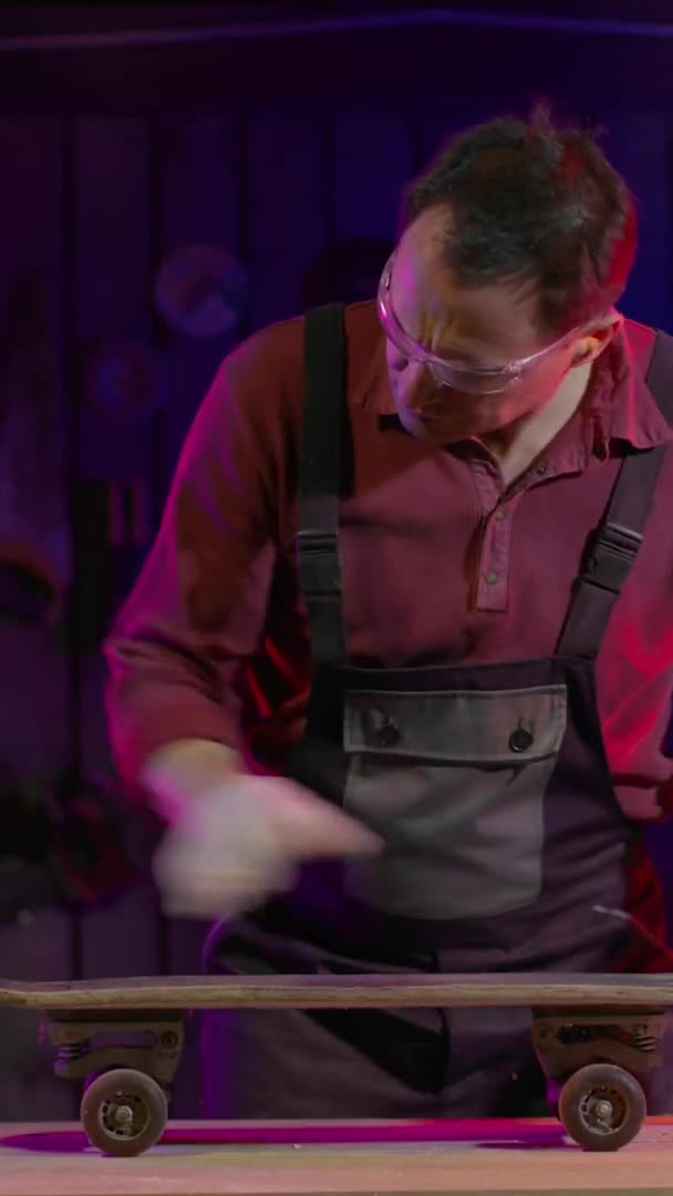 穿着工作服和护目镜修理滑板的成年男性木匠 — 图库视频影像