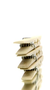 İzole edilmiş beyaz arkaplanda dönen kıyafetleri kurutmak için dikey video tahta mandal