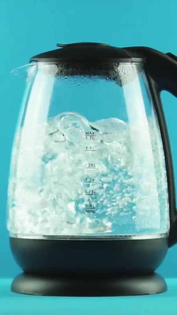 Vertikal video En vattenkokare med transparenta väggar. Aktivt kokande. Närbild. Studioinspelning — Stockvideo