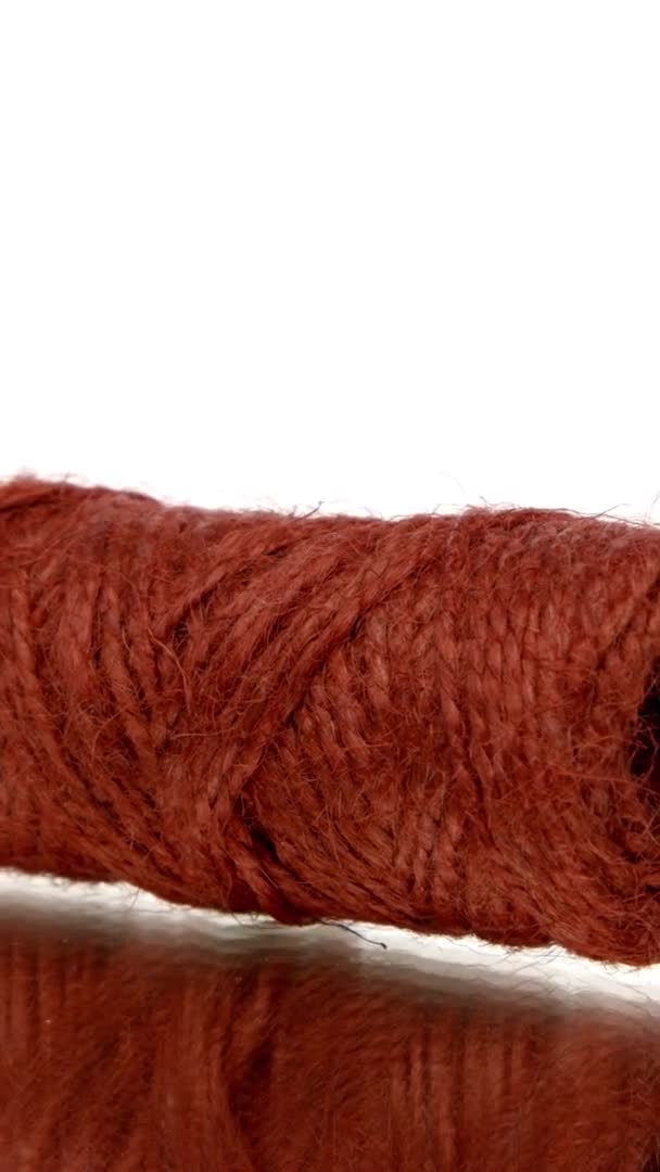 Vidéo verticale Skein de ficelle de jute rouge tournant sur fond blanc isolé. Naturel recyclé — Video