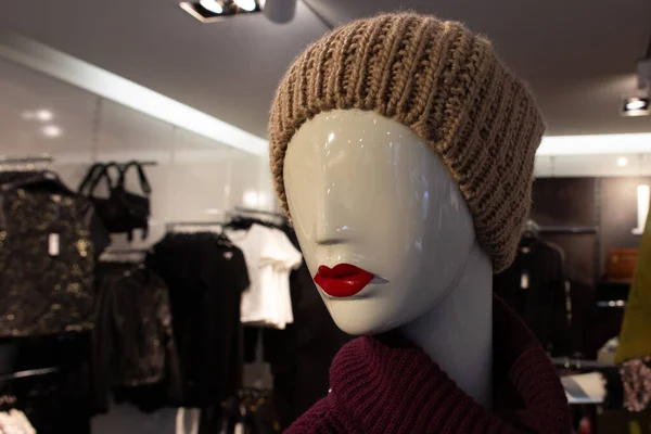 white mannequin head with red lips in knitted cap