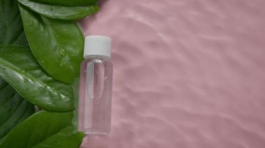 Yeşil yapraklar üzerinde nemlendirici jel losyonu ve dalgalı su yüzeyi ağır çekim