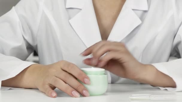 Young female researcher cosmetologist examines new moisturizing cream features — Stock Video