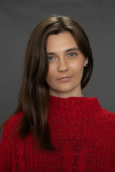 Young charming woman in red looks at camera on dark background, natural beauty — Stock Photo, Image