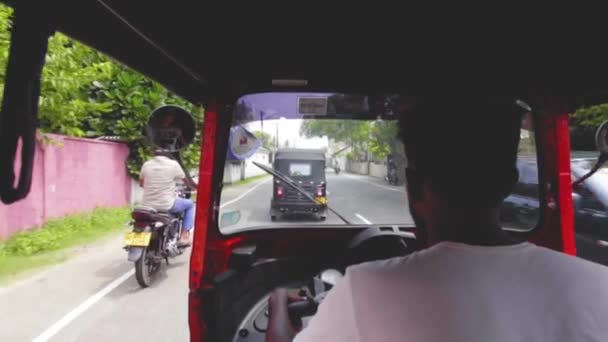 Galle, Srí Lanka, 1.12.2020 - pohled z ulice tuk tuk. místní muž jezdí na skútru — Stock video