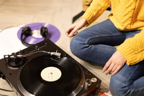 Ragazza seduta sul pavimento mette il disco sul giradischi. Rilassato Lunging musicale a casa — Foto Stock