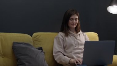 Çekici uzun saçlı esmer kız internette müzik dinlerken eğleniyor.