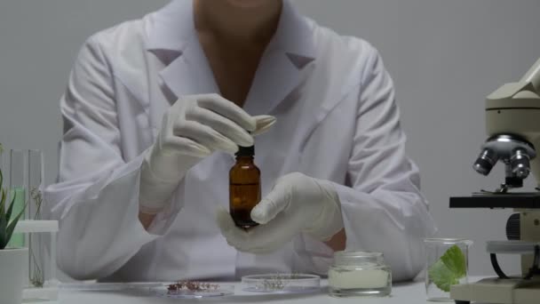 Klinikteki kozmetik malzemeleri test eden yakın çekim bilim adamı. — Stok video