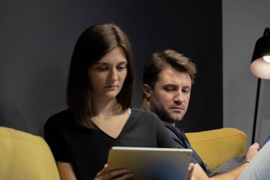 Adam kıskanç bir şekilde kız arkadaşının tabletine bakar ve kiminle konuştuğunu öğrenir.