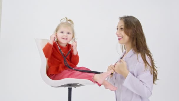 Adorable feliz niña alegre escuchando pulmones Pretty Female Doctor — Vídeo de stock