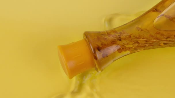Kosmetyki ziołowe. falowanie Woda otacza butelkę naturalnego oleju i nasion roślin — Wideo stockowe