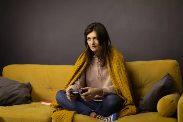 Attrayant fille aux cheveux longs Jouer au jeu vidéo seul assis sur un canapé jaune confortable — Photo
