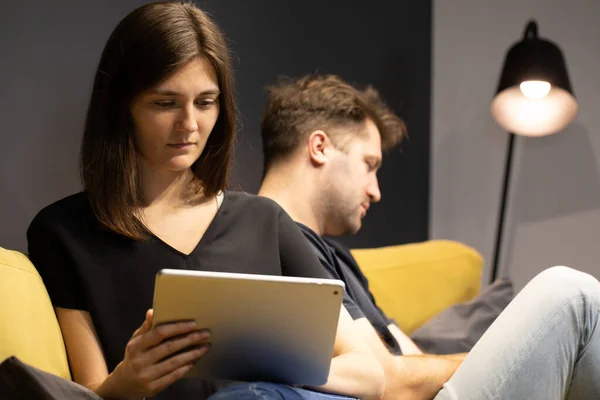 Chica atractiva usando tableta leer noticias, charlando en línea, ignorando novio — Foto de Stock