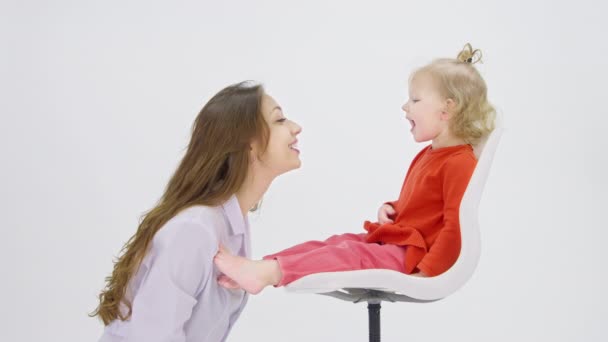 遊び心のある赤ちゃんは、医師の前で椅子に座って舌喉を示しています,ヘルスケア — ストック動画