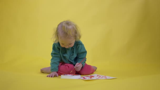 Niña adorable niño recoge pintura en la paleta y dibuja imagen de los niños — Vídeo de stock