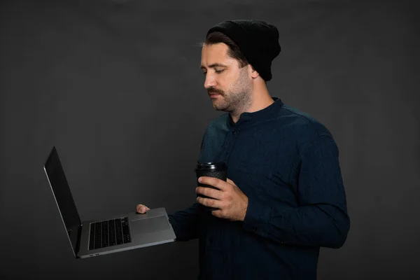 Stilvolle Freelancer männliche Fernbedienung Blick auf Laptop-Bildschirm mit Kaffee — Stockfoto