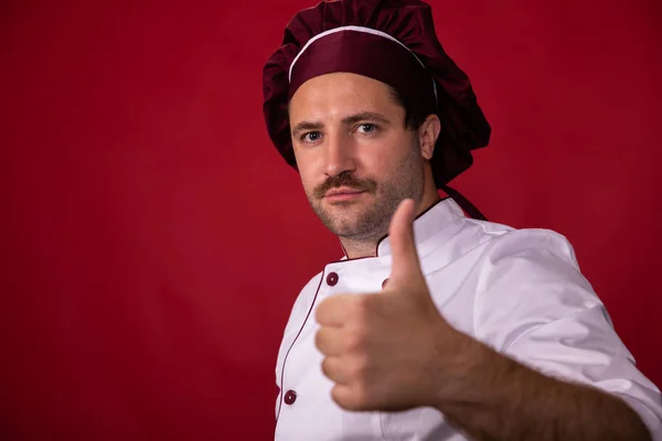 Retrato de guapo chef en uniforme mostrando como signo, mejores consejos de cocina —  Fotos de Stock