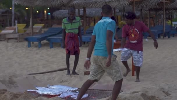Hikkaduwa, Sri Lanka, 1.12.2020 - I residenti locali friggono pesci in lamina su griglia di sabbia — Video Stock