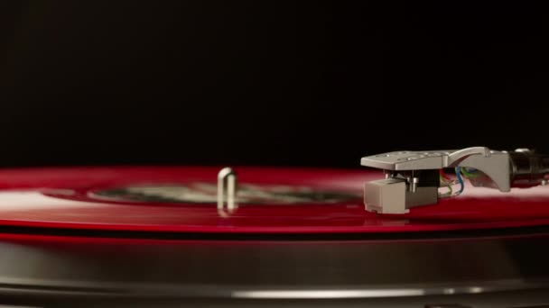 Rood vinyl plaat spinnen op draaitafel geïsoleerd op zwart. LP speler in beweging — Stockvideo