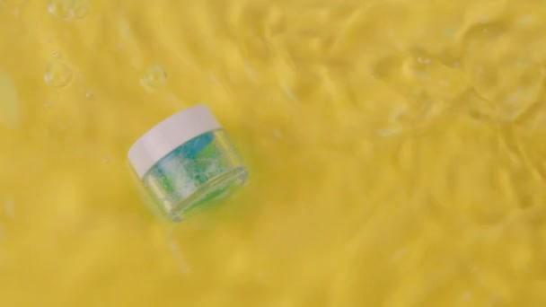 Rimpelend water omringt Innovatieve schuimende blauwe hydraterende gel in glazen pot — Stockvideo