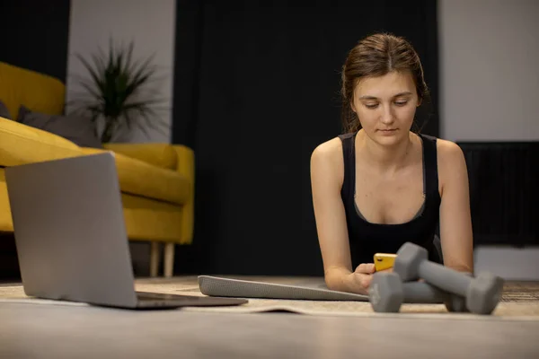 No hay dolor, no hay resultados Pensativo Lazy Girl acostado en la esterilla de yoga mirando el teléfono inteligente — Foto de Stock