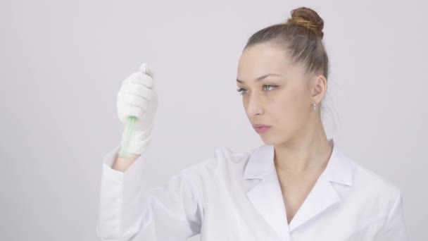 Femmina ricercatrice agitazione giallo verde liquido chimico in provetta — Video Stock