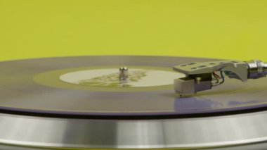 Pikapta dönen mavi plak sarıda izole edilmiş. LP oynatıcı hareket halinde