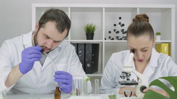 Dos científicos trabajan en laboratorio desarrollando productos para el cuidado de la piel que soportan microbiomas — Vídeos de Stock