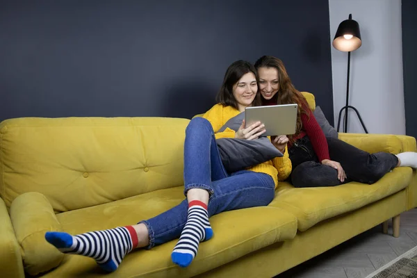 Joven pareja lesbiana hacer compras o pagos en línea acostado en sofá — Foto de Stock