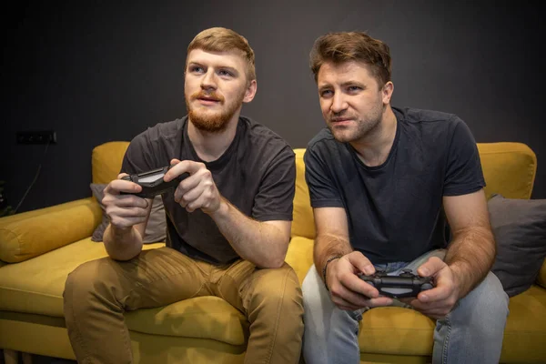 Mâle homosexuel couple passionnément jouer jeu vidéo tenant console joysticks — Photo