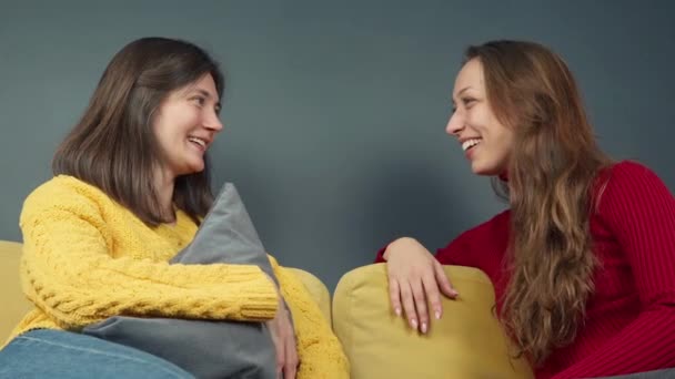 웃는 두 소녀가 아늑 한 소파 소녀에 대한 소문 이야기를 하며 하이파이브를 한다 — 비디오