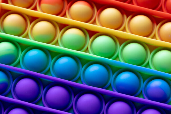 Close-up Pop It texture colorful rainbow background, anti-stress Fidget toy