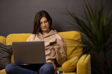 Kız internetten satın alma ya da ödeme yapıyor. Kredi kartı CVV güvenlik koduna bakıyor.