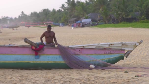 Hikkaduwa, Sri Lanka, 1.12.2020 - Un pêcheur tire des filets de pêche dans un bateau coloré — Video