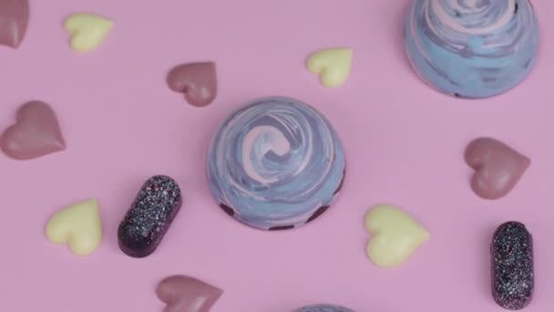 Вишуканий смачний кондитерський цукерки ручної роботи, що обертається на рожевому столі — стокове відео