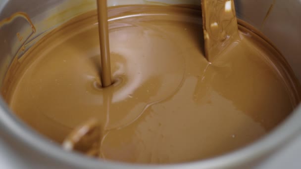 Jetstråle av smält mjölkchoklad häller i smoll mixer eller omrörare. — Stockvideo