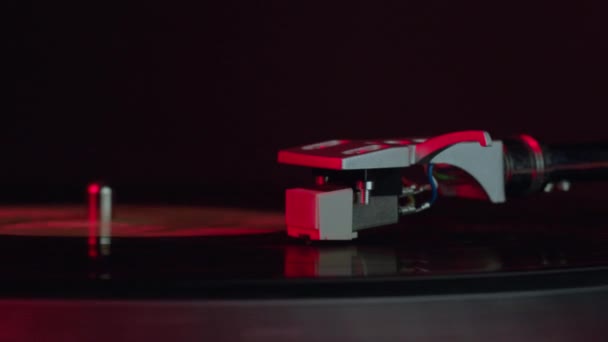 Rekaman vinyl hitam berputar pada turntable pada lampu merah Neon LP player in motion — Stok Video