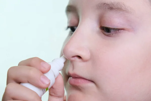 鼻水の少年は手に薬を持っています 鼻スプレー灌漑アレルギー性鼻炎や副鼻腔炎を停止します — ストック写真