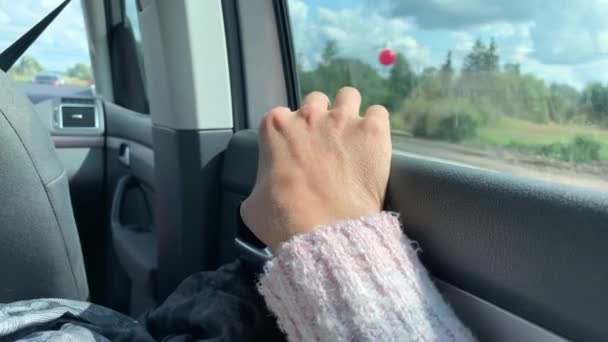 Una mano de una mujer montando un coche como pasajero en taxi, vista al campo desde una ventana — Vídeos de Stock